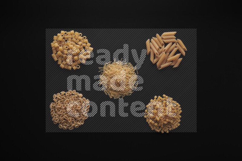 Different pasta types in bunches on black background
