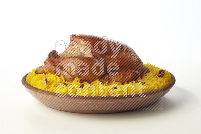 yellow basmati Rice with whole roasted chicken  on a pottery plate  direct  on white background