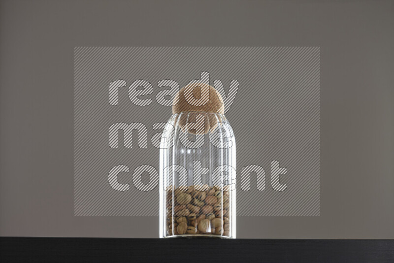 Fava beans in a glass jar on black background
