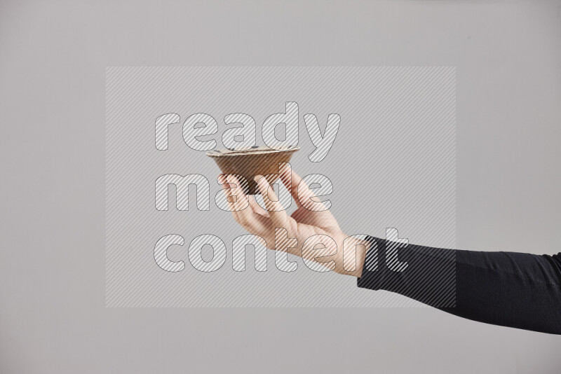 A woman in black abaya holding different pottery essentials in different positions