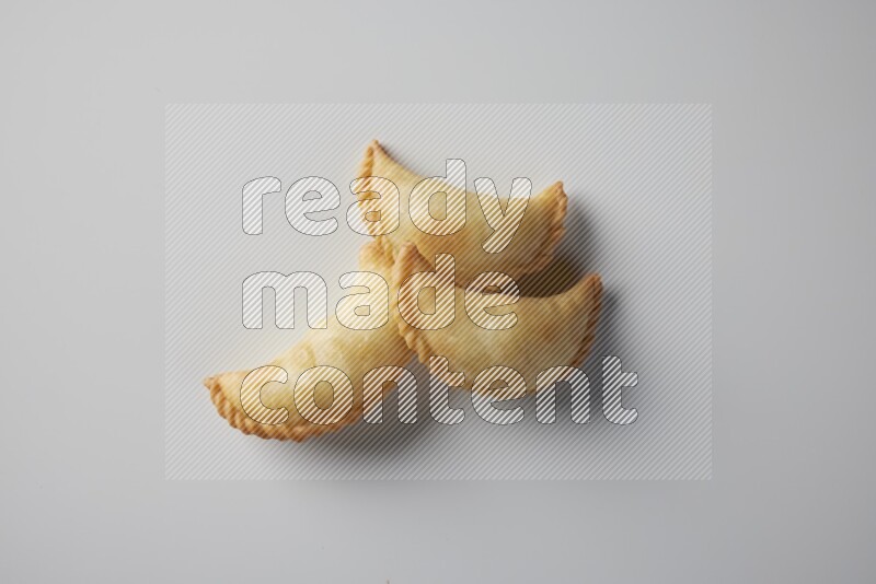 Three fried sambosa from a top angle on a white background