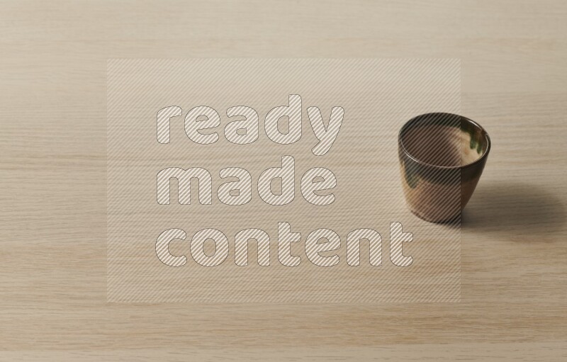 A pottery cup on light wooden background