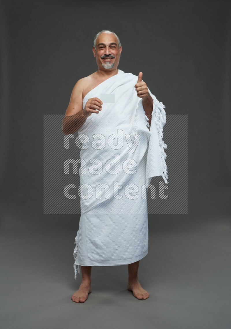 A man wearing Ehram Standing holding ATM card on gray background