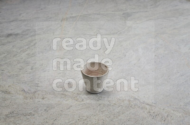 A multicolored pottery Cup on grey marble background