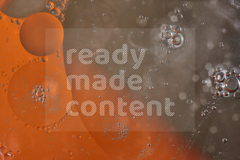 Close-ups of abstract oil bubbles on water surface in shades of orange and brown