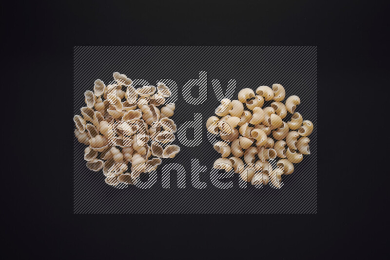 Different pasta types in bunches on black background