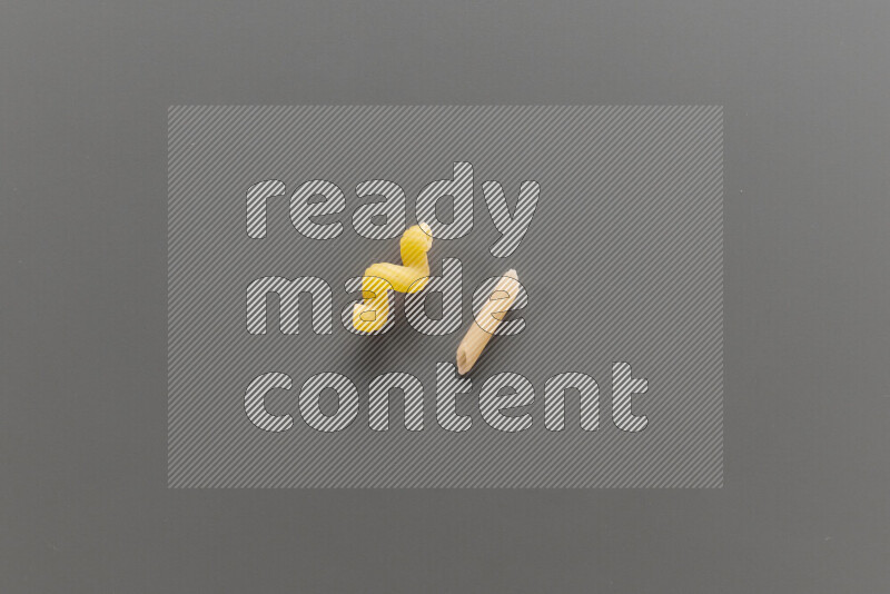 Twist pasta with other types of pasta on grey background