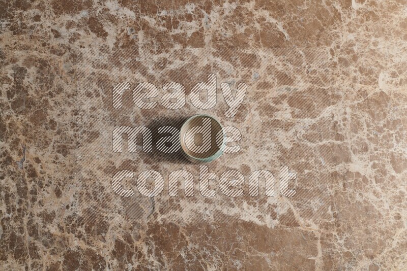 A multicolored pottery bowl on beige marble background