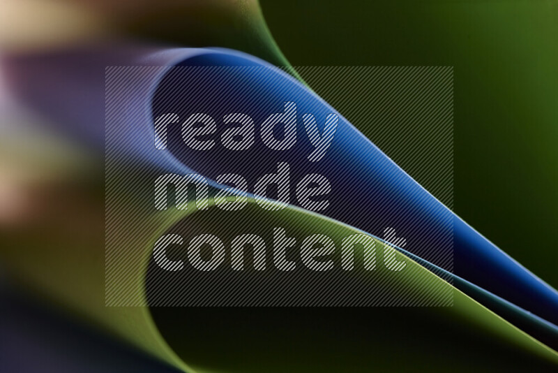 An abstract art showing blue and green paper sheets arranged in an overlapping curves