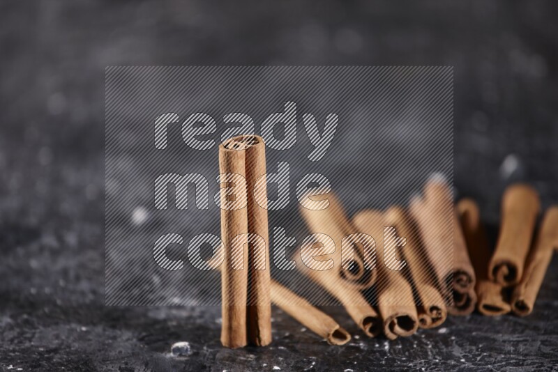 Cinnamon sticks on a textured black background
