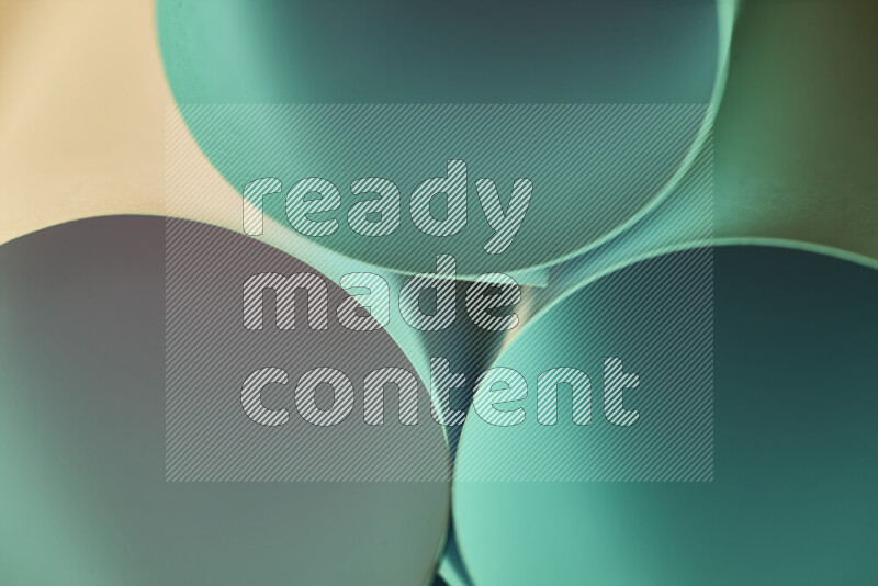 The image shows an abstract paper art with circular shapes in varying shades of green and warm tones