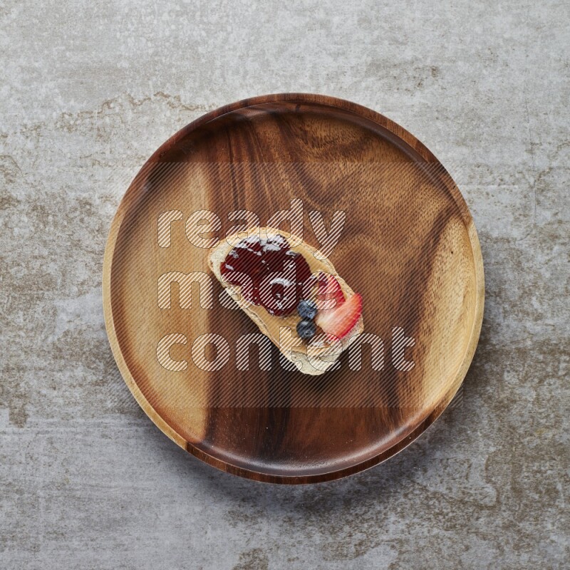 open faced peanut butter sandwich with jam, strawberries and blueberries & chia on a  grey textured background