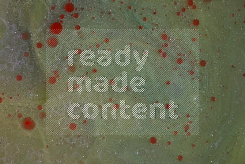 The image captures a dramatic splatter of red paint over a green backdrop