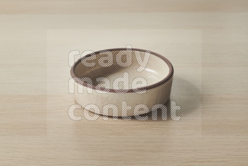 A beige pottery oven plate on light wooden background
