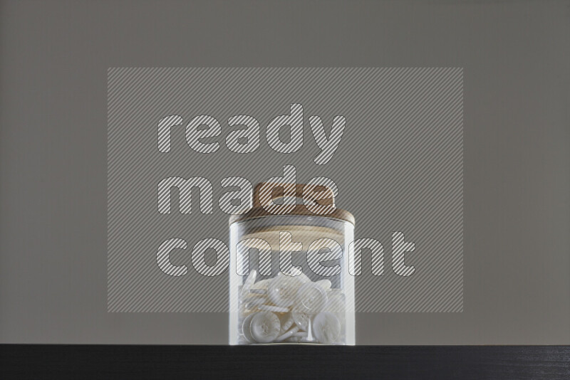 Buttons in a glass jar on black background
