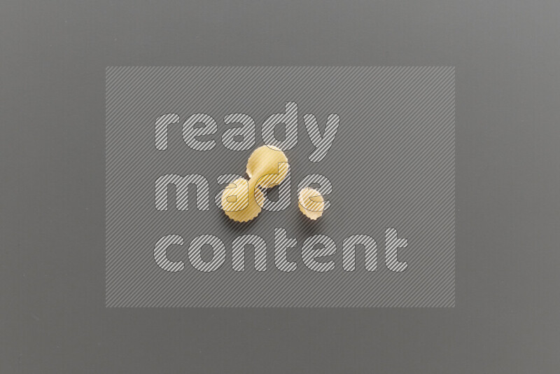 معكرونة فيونكة مع أنواع أخري من المعكرونة علي خلفية رمادية