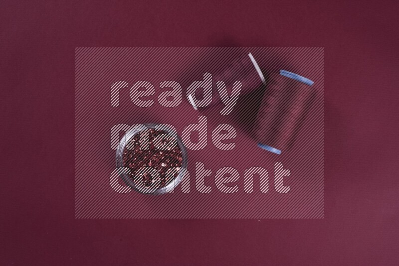 مجموعة من أدوات الخياطة والتفصيل حمراء اللون على خلفية حمراء