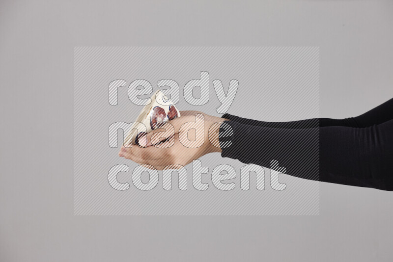 A woman in black abaya holding different pottery essentials in different positions