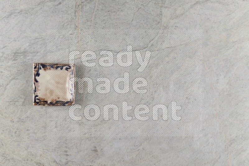 A decorative pottery plate on grey marble background