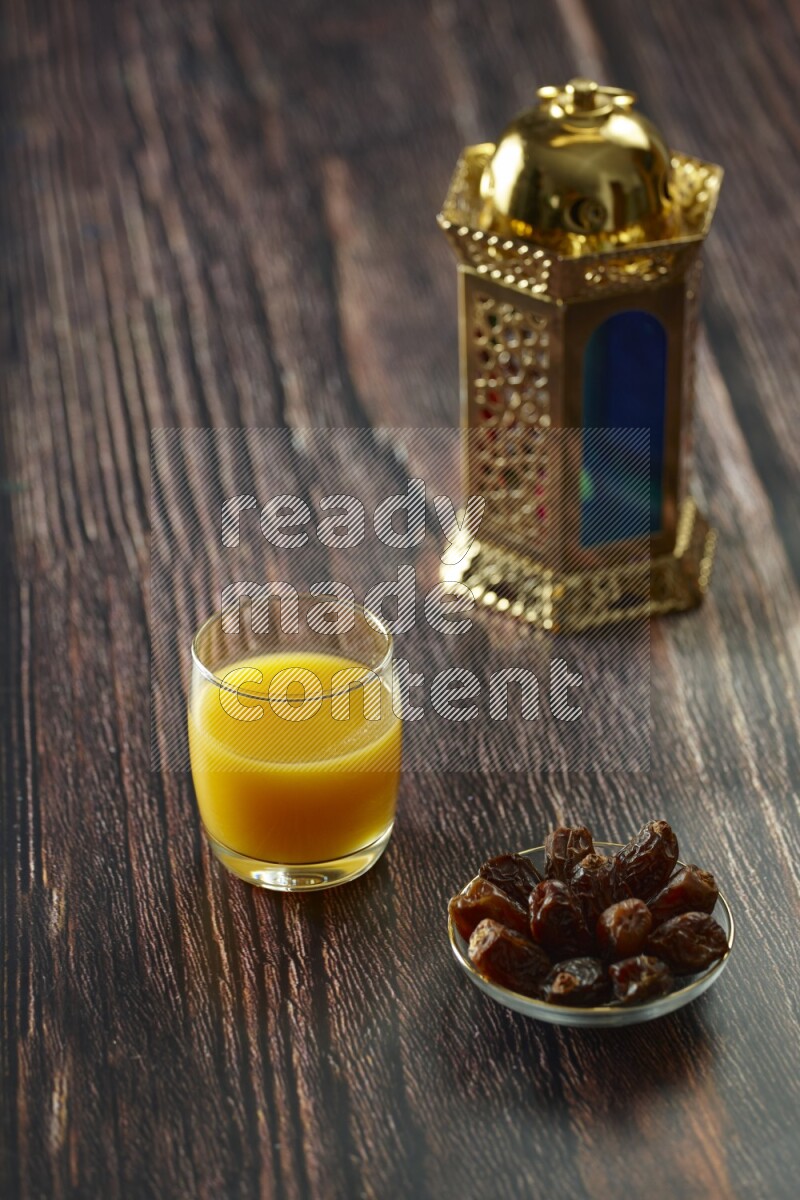 A golden lantern with different drinks, dates, nuts, prayer beads and quran on brown wooden background