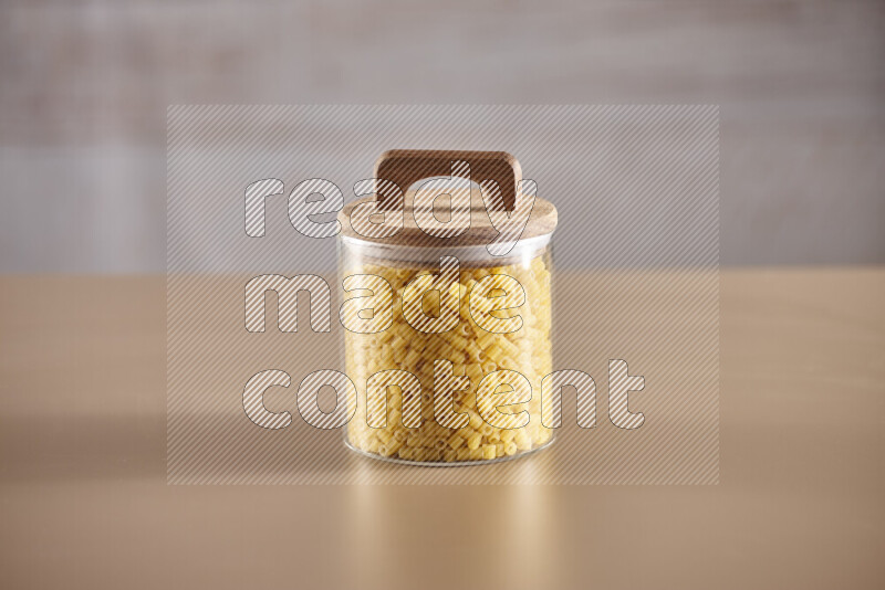 Raw pasta in glass jars on beige background