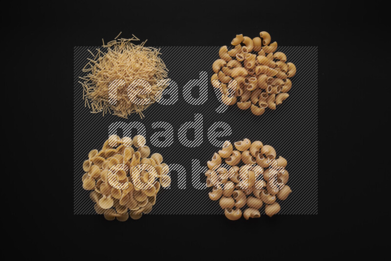 Different pasta types in bunches on black background