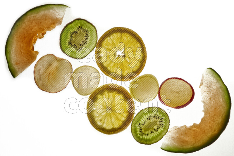 Mixed fruits slices on illuminated white background