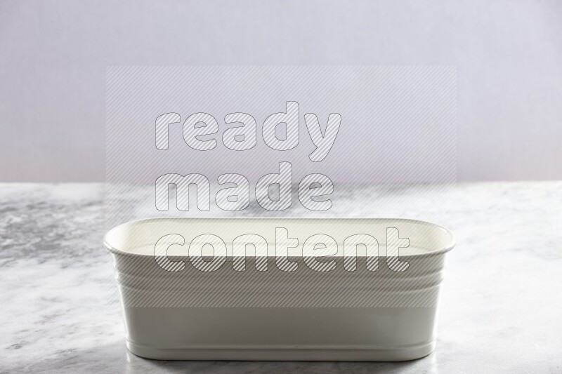 An empty white plant pot on grey marble background