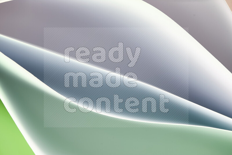 This image showcases an abstract paper art composition with paper curves in green and white gradients created by colored light