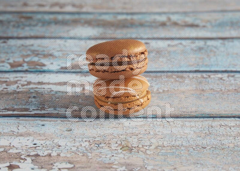 45º Shot of of two assorted Brown Irish Cream, and Brown Coffee macarons on light blue background