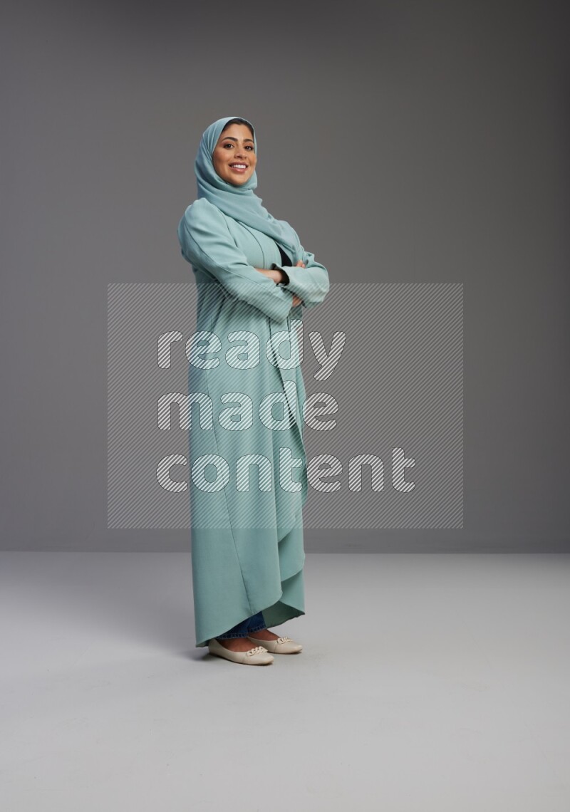 Saudi Woman wearing Abaya standing with crossed arms on Gray background