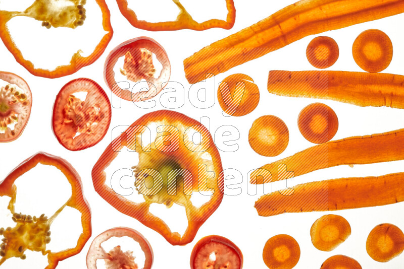 Mixed vegetables and fruits slices on illuminated white background