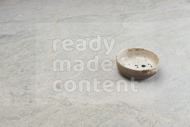 A multicolored pottery bowl on grey marble background