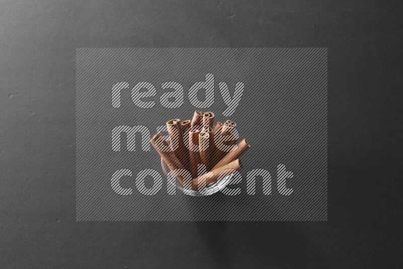 أعواد القرفة في وعاء زجاجي علي خلفية سوداء