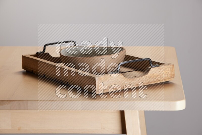 multi colored  bowl on a light colored rectangular wooden tray with handles