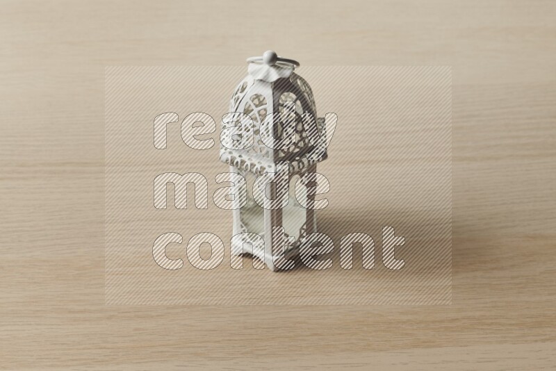A candle lantern on light wooden background