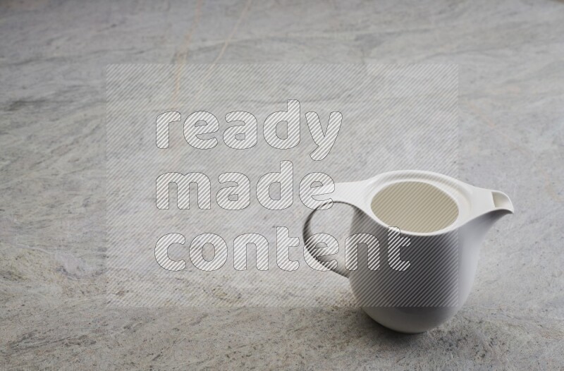 A ceramic milk jug on grey marble background