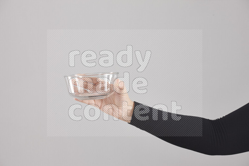 امرأة ترتدي عباءة سوداء تحمل أدوات زجاجية مختلفة في أوضاع متعددة