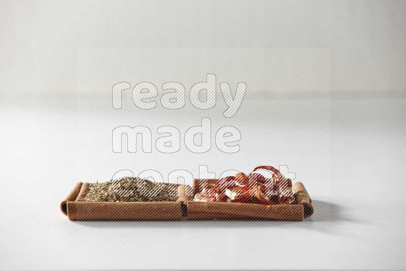 2 squares of cinnamon sticks full of dried red chilis and cumin on white flooring