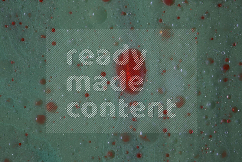 The image captures a dramatic splatter of red paint over a green backdrop