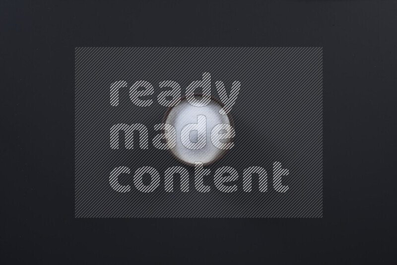 وعاء فخاري ممتلئ بملح الطعام الناعم وملح البحر الخشن على خلفية سوداء