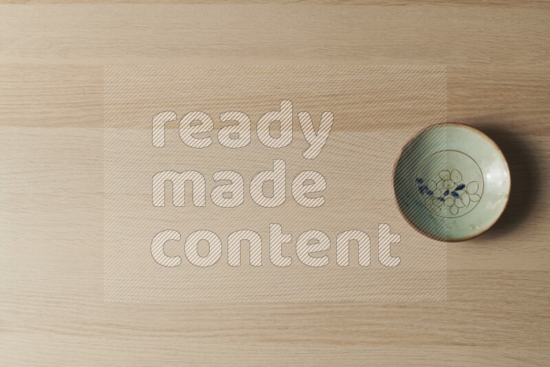 A decorative pottery plate on light wooden background