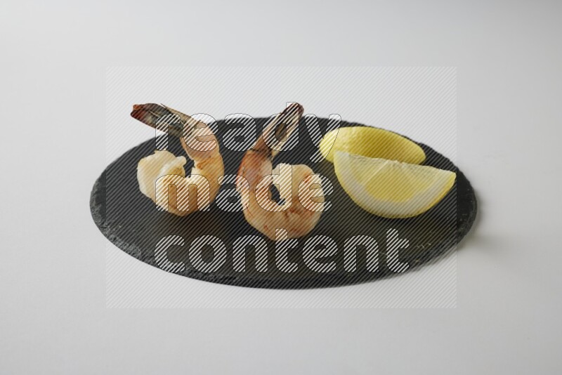 two grilled shrimp  on a black slate direct  on a white back ground