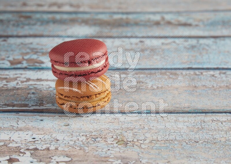 45º Shot of of two assorted Brown Irish Cream, and Red Velvet macarons on light blue background