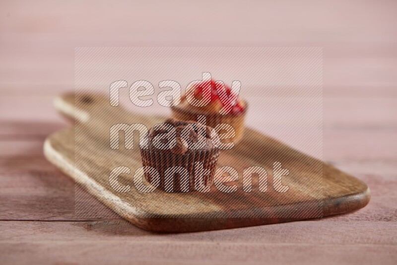 Chocolate mini cupcake topped with chocolate chips on a wooden board