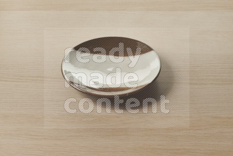 A multicolored pottery plate on light wooden background