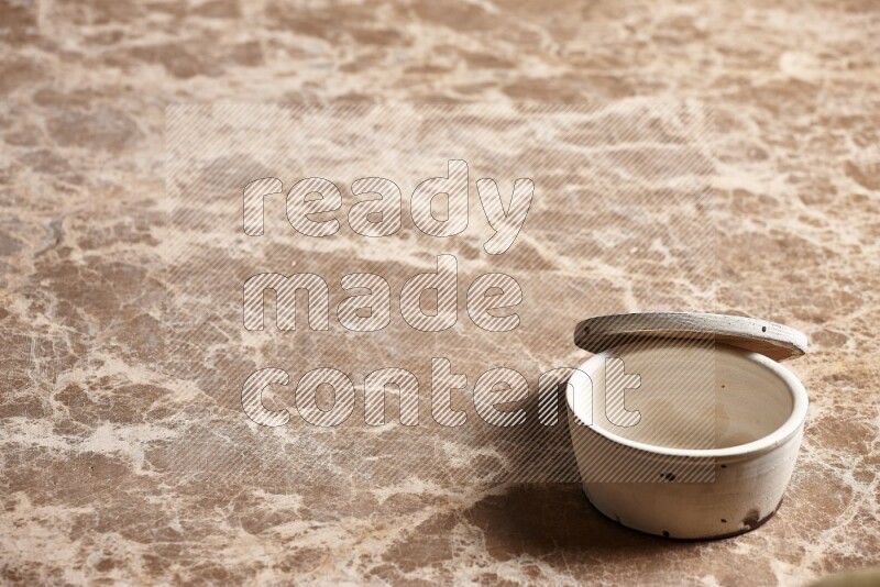 A white pottery bowl on beige marble background