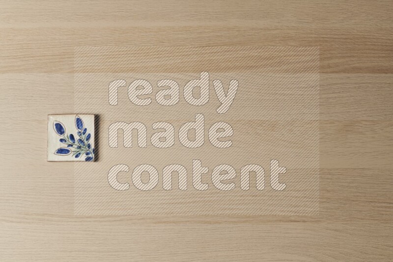 A decorative pottery coaster on light wooden background