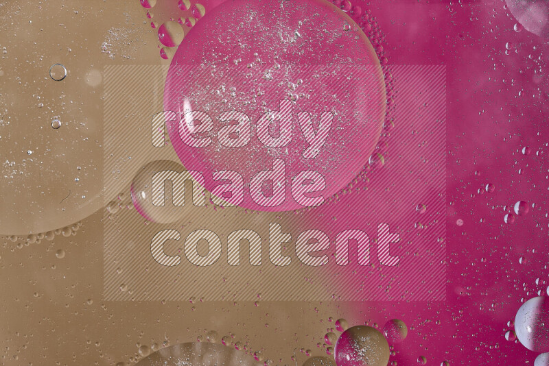 لقطات مقربة لفقاعات من الزيت على سطح الماء باللون الوردي والبني