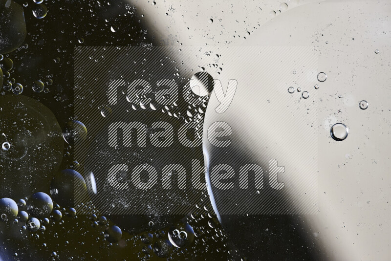 Close-ups of abstract oil bubbles on water surface in shades of black and beige